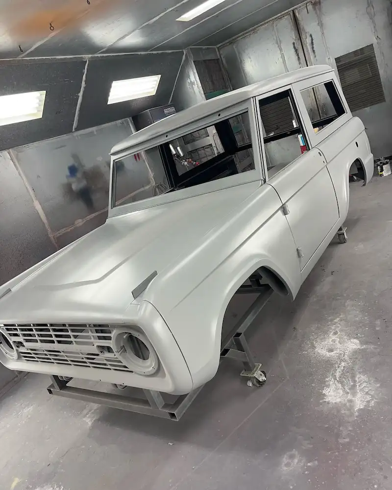 white ford bronco being painted in paint booth